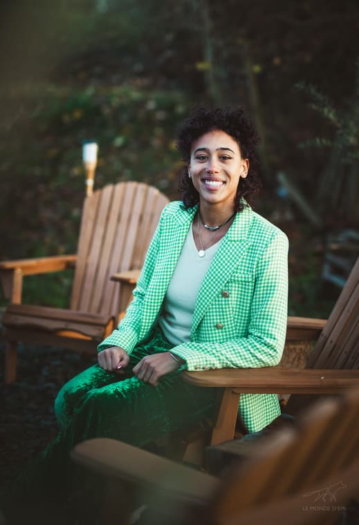 Nadège assise en extérieur, souriante